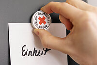 Das Foto zeigt einen DRK Magnet, der das Wort "Einheit" anpinnt.