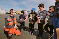 Das Foto zeigt einen DRK Helfer mit geflüchteten Kindern